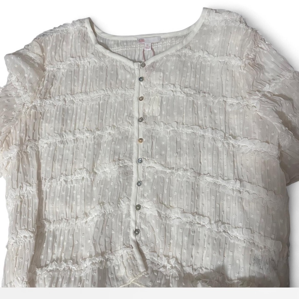 White sheer blouse with ruffles and button-up front.